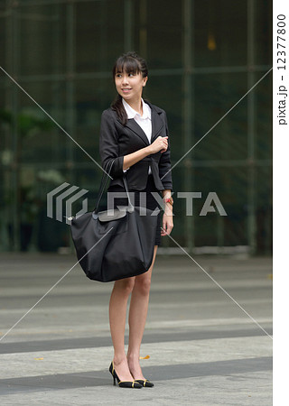 One young successful chinese business woman with bag outside office building 12377800