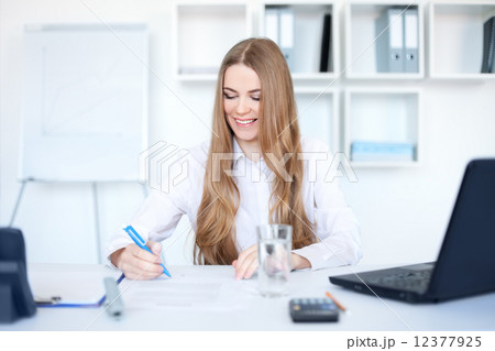Portrait of a beautiful young smiling business woman doing some Portrait of a beautiful young smiling business woman doing some 12377925