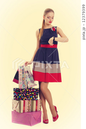 Beautiful girl with shopping bags looking at his watch. Pin-up s 12379399