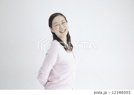 ４０代女性爽やか笑顔自然光ポートレイト 12386003