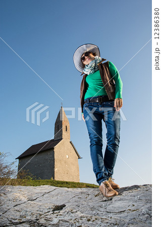 Posing young woman in a stylish hat and an old romanesque church Posing young woman in a stylish hat and an old romanesque church 12386380