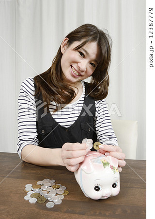 小銭貯金する若い女性 12387779