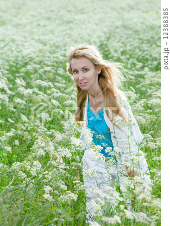 The happy young woman in the field of white wild flowers.. The happy young woman in the field of white wild flowers.. 12388385