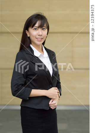 Portrait of one successful young chinese business woman in front of yellow marble wall Portrait of one successful young chinese business woman in front of yellow marble wall 12394375