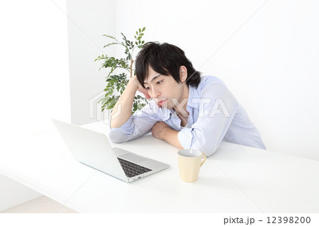 パソコンと憂鬱そうな若い男性 12398200