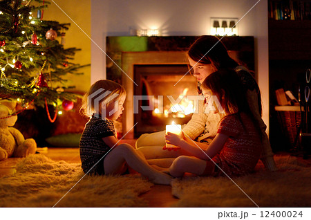 Happy family by a fireplace on Christmas 12400024