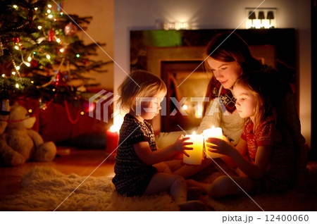 Happy family by a fireplace on Christmas 12400060