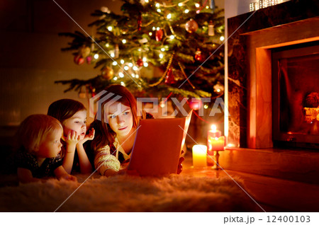 Mother and her daughters reading a book 12400103