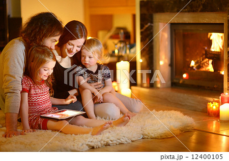 Happy family by a fireplace on Christmas Happy family by a fireplace on Christmas 12400105