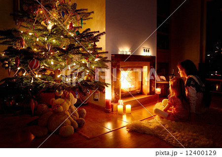 Young mother and her daughter by a fireplace 12400129