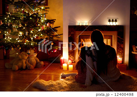 Young mother and her daughter by a fireplace Young mother and her daughter by a fireplace 12400498