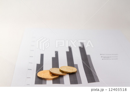 Gold coins on financial charts Gold coins on financial charts 12403518