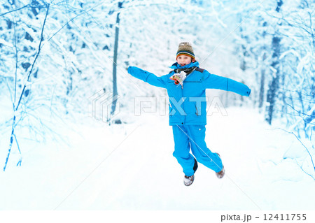 Funny boy jumping in a snowy park Funny boy jumping in a snowy park 12411755