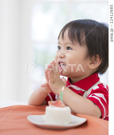 ケーキのろうそくに息を吹く男の子 12412685