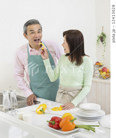 エプロン姿でキッチンに立つ夫婦 12413028