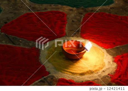 oil lamp lit on colorful rangoli, diwali celebration 12421411