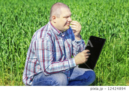 Farmer with folder near the cereal field  12424894