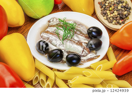 Anchovy fillets with olives and vegetables around on a table Anchovy fillets with olives and vegetables around on a table 12424939