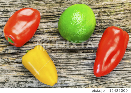 Peppers with lime on old wooden board  12425009