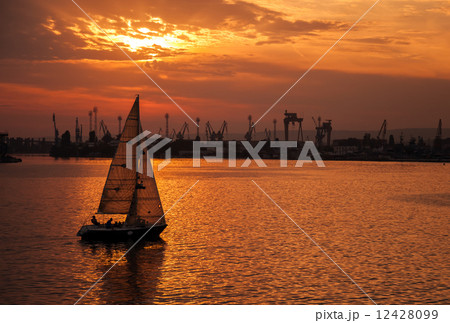 Sailing yacht goes in Varna harbor at the sunset Sailing yacht goes in Varna harbor at the sunset 12428099