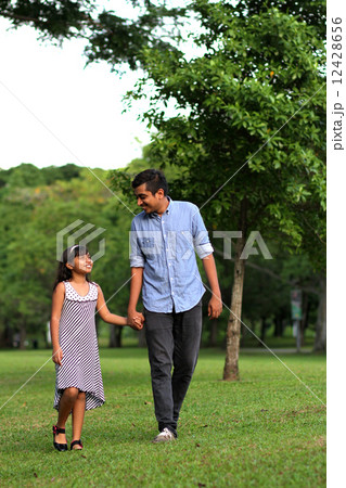 Asian Father and daughter enjoying a stroll at the park Asian Father and daughter enjoying a stroll at the park 12428656