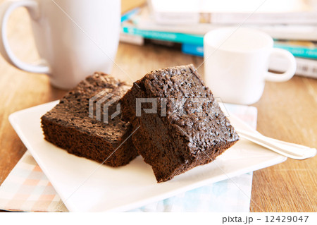 browny cake ready to eat on white dish with coffee cup and magaz 12429047