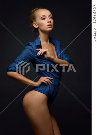 Beautiful  naked woman in blue shirt posing in studio. 12433757