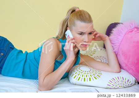 teen girl talking to mobile phone in her room teen girl talking to mobile phone in her room 12433869