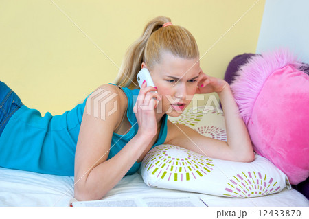 teen girl talking to mobile phone in her room 12433870