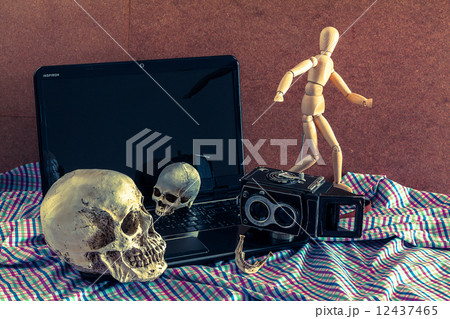 Still life of skull,wooden figure, old vintage camera and notebo Still life of skull,wooden figure, old vintage camera and notebo 12437465