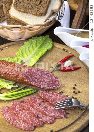 sausages on a wooden plate with vegetables in a restaurant 12442192