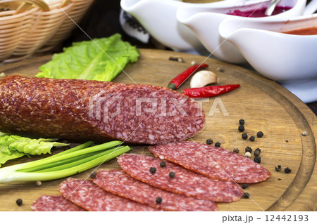 sausages on a wooden plate with vegetables in a restaurant 12442193