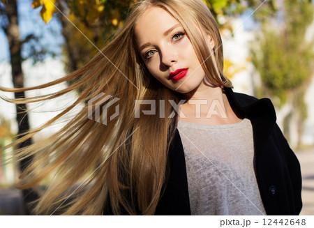 Pretty girl with flying hairs in colorful leaves 12442648