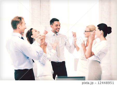 business team celebrating victory in office business team celebrating victory in office 12448951
