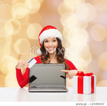 smiling woman with credit card and laptop 12449347