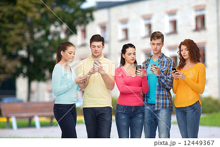 group of serious teenagers with smartphones group of serious teenagers with smartphones 12449367