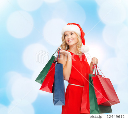 woman in santa helper hat with shopping bags 12449612