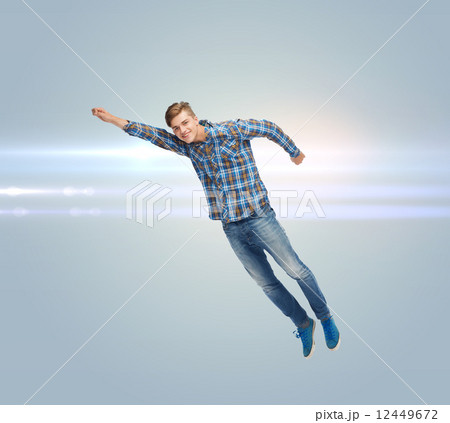 smiling young man jumping in air smiling young man jumping in air 12449672