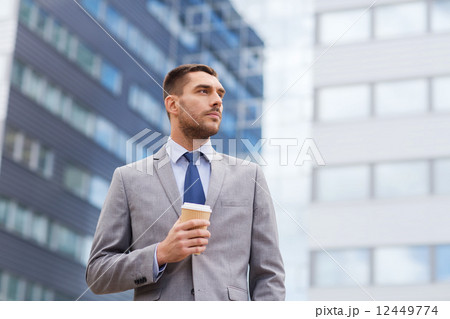 young serious businessman with paper cup outdoors young serious businessman with paper cup outdoors 12449774