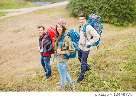 group of smiling friends with backpacks hiking 12449776