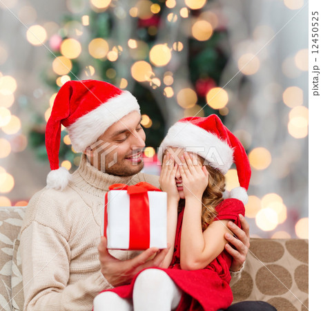 smiling daughter waiting for present from father 12450525