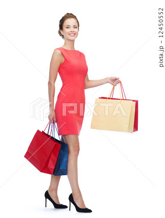 smiling elegant woman in dress with shopping bags 12450552