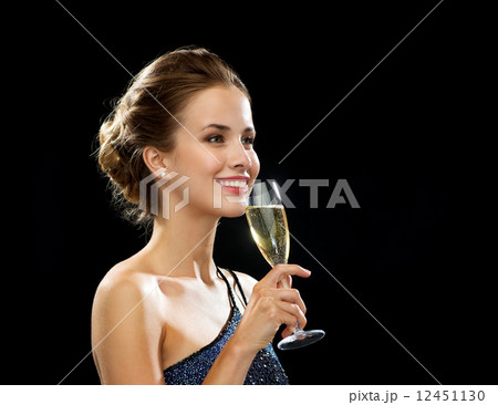 smiling woman holding glass of sparkling wine smiling woman holding glass of sparkling wine 12451130