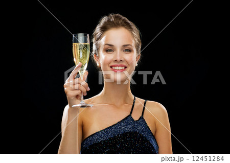 smiling woman holding glass of sparkling wine smiling woman holding glass of sparkling wine 12451284