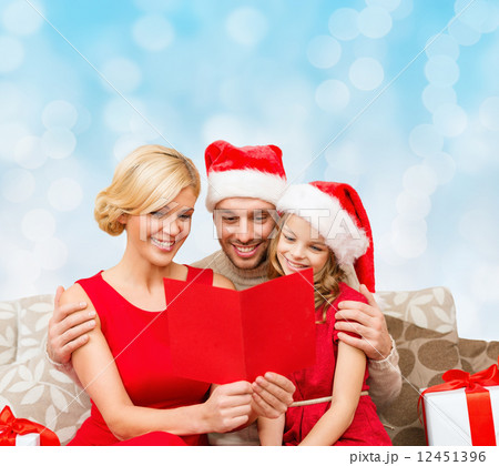 happy family in santa hats with greeting card happy family in santa hats with greeting card 12451396