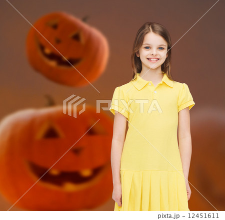 smiling girl in dress over pumpkins background 12451611