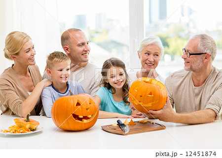 happy family sitting with pumpkins at home 12451874