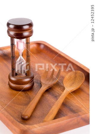 Hourglass on a plate with a fork and knife for food and time con Hourglass on a plate with a fork and knife for food and time con 12452395