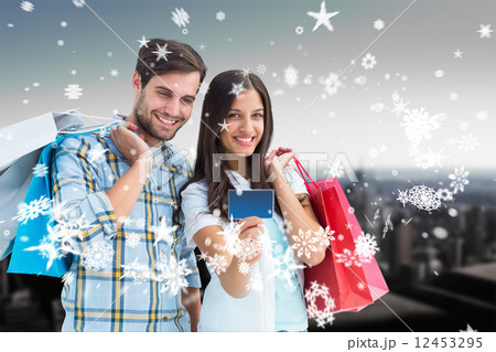 Composite image of couple with shopping bags and credit card 12453295