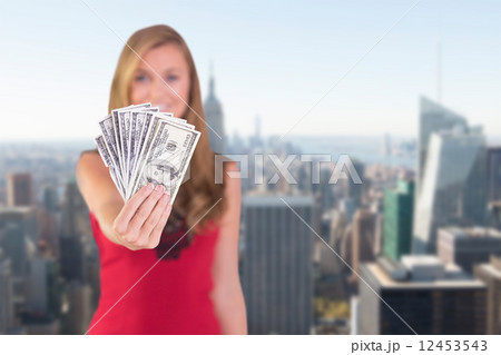 Composite image of pretty blonde showing wad of cash Composite image of pretty blonde showing wad of cash 12453543